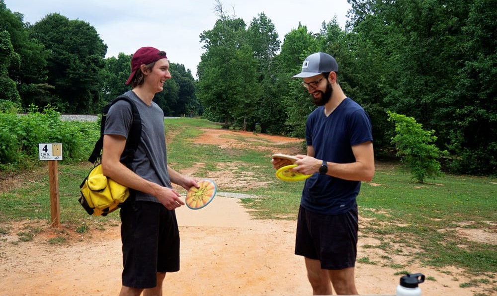 friends laughing playing disc golf