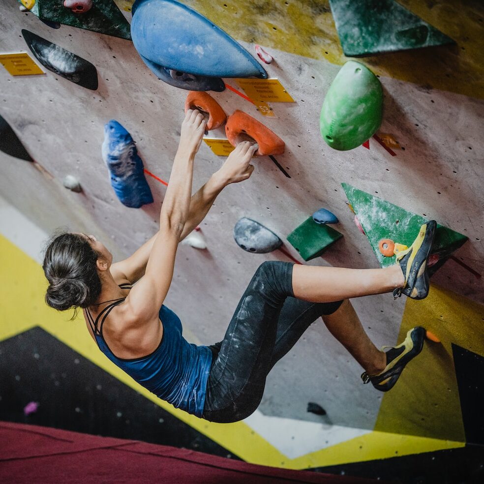 woman rock climbing inside building